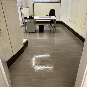 Modernes, helles Büro mit Schreibtisch, Stuhl und großen Fenstern, ideal für produktives Arbeiten.